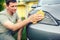 Wiping car- Smiling male cleaning car with microfiber cloth, car