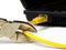 Wire cutter cutting network cable from laptop on white background