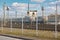 Wire fence restricting access to train depot with standing trains out of focus railway depot background. Concept of protecting