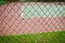 Wire fence with tennis court on background