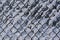 Wire mesh fence covered with snow as a seasonal winter background texture