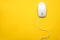 Wired computer mouse on yellow background. Space for text