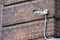 Wired surveillance camera mounted on a brick wall. White wire anti-theft security camera mounted on an old brick wall