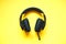 Wireless black gaming headphones on yellow background