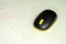 Wireless black and yellow colored computer mouse  on white cloth