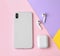 Wireless earphones, mobile phone and charging case on color background