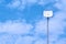 Wireless internet antenna against blurred blue sky and white cloud background.