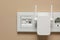 Wireless Wi-Fi repeater in power socket on beige wall