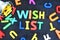 Wish list concept with colorful letters on blackboard pouring out from a metallic bucket