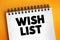 Wish List - itemization of goods or services that a person or organization desires, text concept on notepad