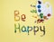 Wish to be happy is written from multicolored chocolates in form of sea pebbles on yellow background