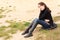 Wistful young woman sitting outdoors alone