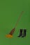 Witch black shoes and broom that cleaning a bunch of shine  and black shoes on a green background
