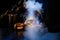 Witch casts a spell on a steaming pumpkin in the dark on Halloween