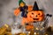 Witch and orange pumpkin in black hat in the small shopping cart
