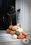 A witch with a pile of pumpkins at the door