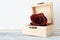 Withered red rose flower on a white wooden shelf.