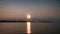 Witness the majestic sight of a full moon as it ascends above a serene body of water, A scene depicting a full moon night, the