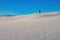 Witness the triumphant spirit of a man raising his hand in triumph with track of footprints at the top of White Sands National