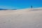 Witness the triumphant spirit of a man raising his hand in triumph with track of footprints at the top of White Sands National