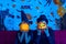 Wizard man and witch woman holding pumpkin close face in sparkle background in halloween party