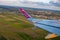 Wizz air company flight, 06/15/2019: tilted frame of land from airplane. Wing of airplane on aerial view of city.