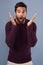 Woah I didnt see that coming. Studio shot of a handsome young man looking surprised against a gray background.