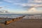 Wodden wave breaker on the beach wit dramatic sky