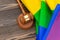 Woden judge mallet symbol of law and justice with lgbt flag in rainbow colours on wooden background