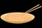 Wok noodles in a bamboo plate with chopsticks on a black background. Vector image