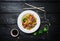 Wok. Udon stir fry noodles with chicken and vegetables in a white plate on black wooden background. With chopsticks and