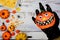 Wolf hand holding pumpkin face with Halloween background. Trick or treat in autumn