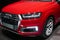 WOLFSBURG, GERMANY - March 22, 2019: Audi Q7 e-tron quattro closeup frontside with lights on and logo in showroom Autostadt