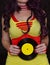 Woman in 1980s yellow clothing holding 45rpm record. Record label painted with yellow poster paint