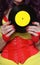 Woman in 1980s yellow clothing holding 45rpm record. Record label painted with yellow poster paint