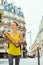 Woman with 2 French baguettes crossing street in Paris, France