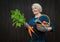 Woman 50-60 years old pensioner farmer holding a basket with organic vegetables grown in his garden. On a dark wooden