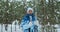 A woman of 60s stands with skis in her hands and looks at the camera with smile