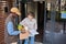 Woman accepting food delivery outdoors and examining fresh groceries