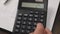 Woman accountant counts on a calculator. Close up