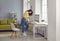 Woman accountant working at home, drinking coffee, using her computer, and looking at some papers