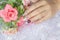 Woman acrylic fingernail painting beautiful white color gel nail art decorated with cute 3D rose flower sparkling rhinestone sweet