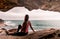 Woman in activewear sitting by the ocean