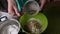 Woman add walnut to food. Cooking a cake of biscuit crumbs and milk jelly. On the surface of the table are the ingredients and coo