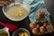 Woman adding butter cubes to batter of beaten eggs and milk in a bowl