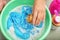 Woman adding detergent into basin with color clothes