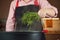 Woman adding fresh dill at chicken soup, chicken broth, in a pot.