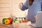 Woman adding herbs to her vegetable stew