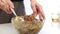 Woman adding honey to a nut butter and mixing ingredients in bowl