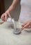 Woman Adding Milk To Chia Seeds In Bowl